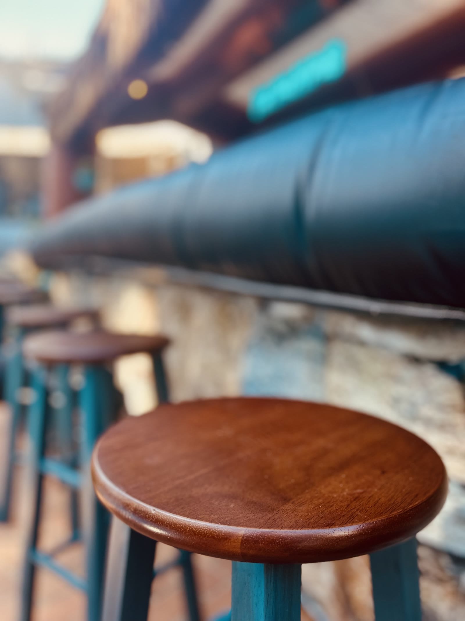 Wooden bar stools lined up along the Palm Pub bar top